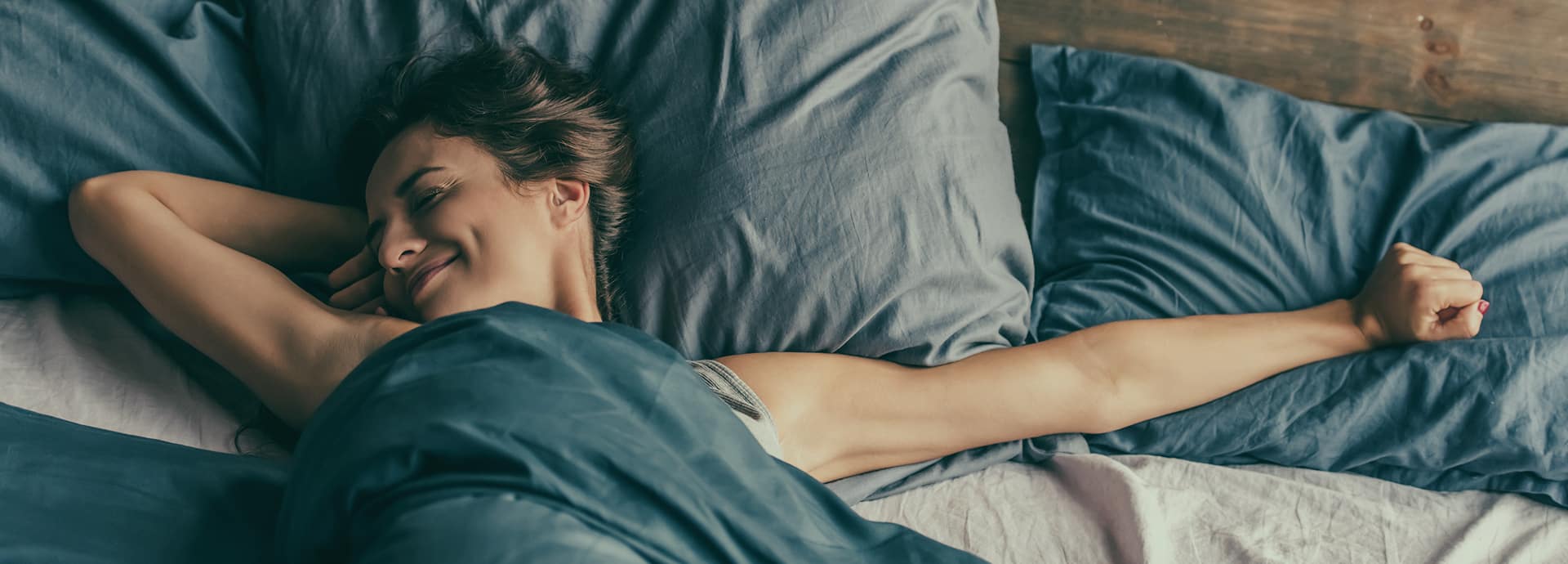 Woman stretching in comfortable bed