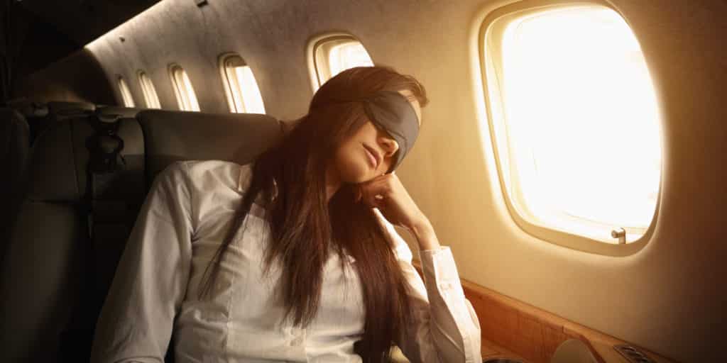 Pacific Islander businesswoman sleeping on private jet wearing a sleep mask