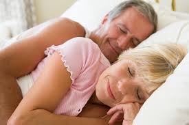 Elderly couple sleeping side by side and smiling contently